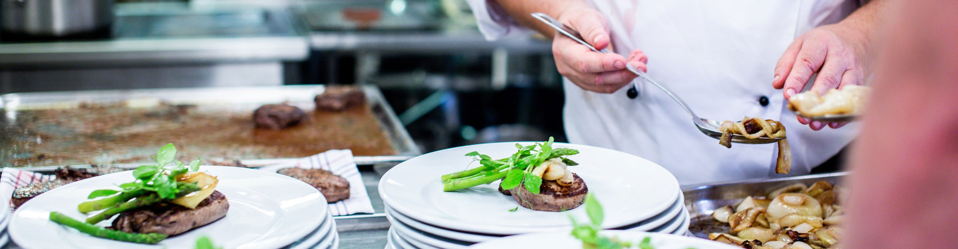 Préparation de plats raffinés par un chef chez Les Délices de Kenza à Bordeaux avec viande, asperges et légumes frais,