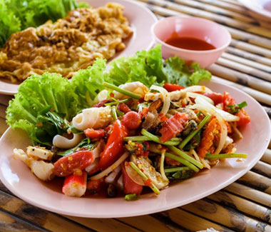 Salade de fruits de mer colorée servie chez Les Délices de Kenza à Bordeaux sur assiette rose,